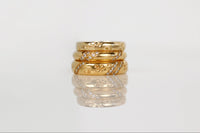 Stack of gold and silver rings on a light gray background